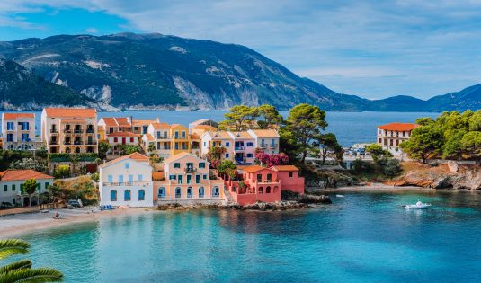 Hermosa vista panorámica del pueblo de Assos con casas de colores vivos cerca de la bahía transparente y de color azul turquesa. Kefalonia, Grecia.